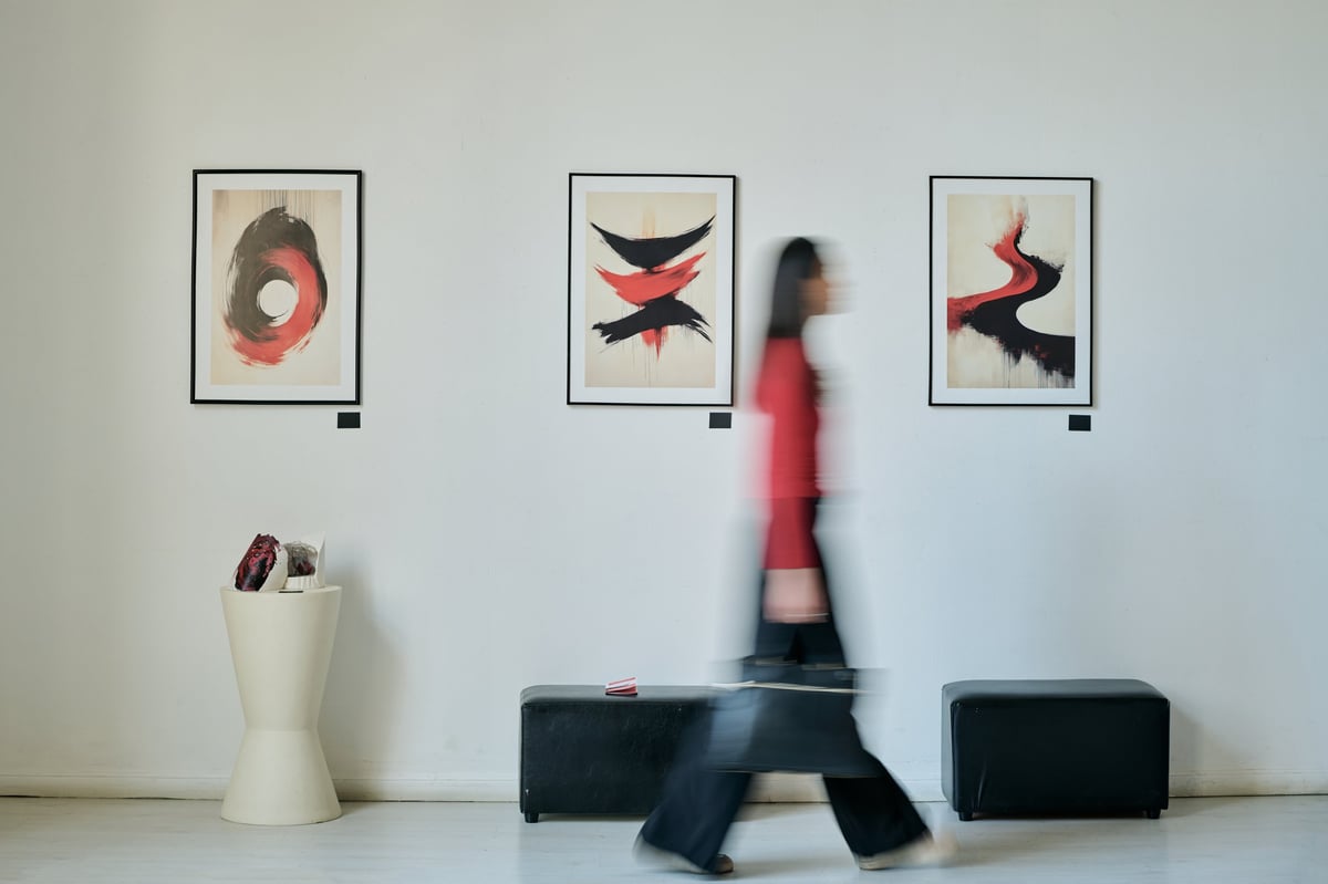 Individual walking past modern art pieces in gallery
