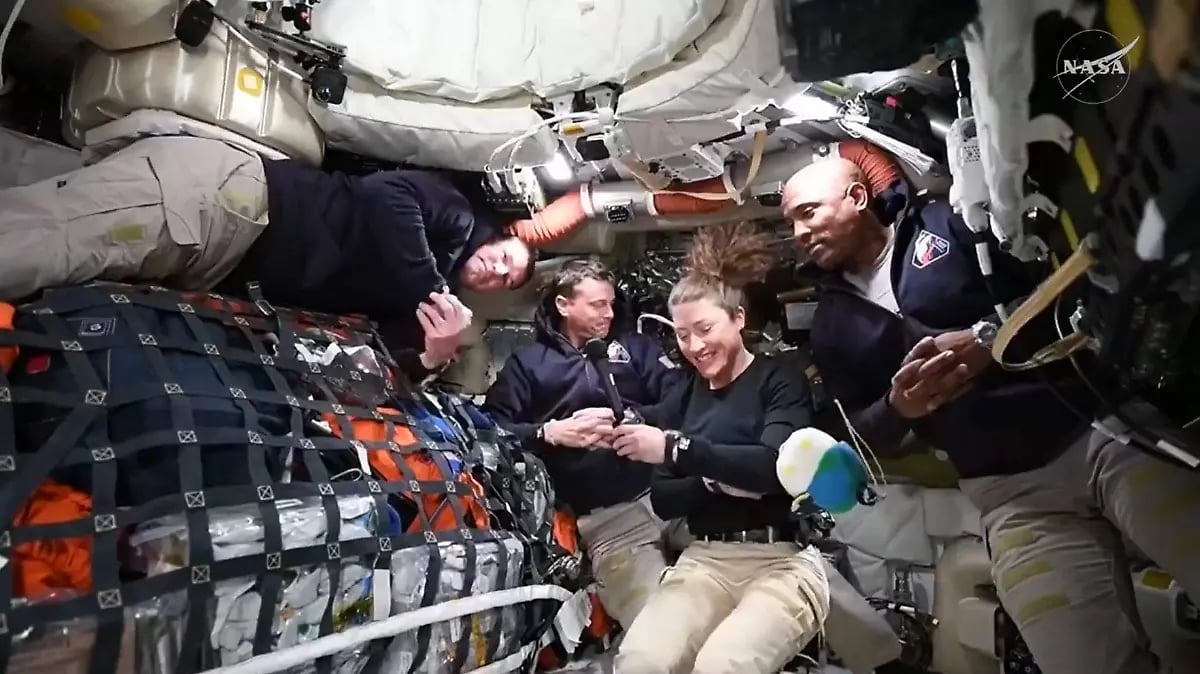 Astronauts working inside a spacecraft cabin with cargo containers and equipment in microgravity