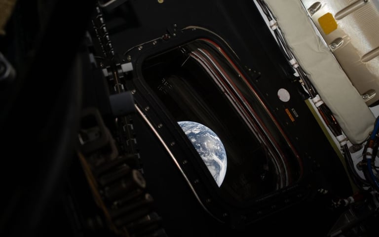 View of Earth from a spacecraft window, showing the planets curved horizon against the blackness of space