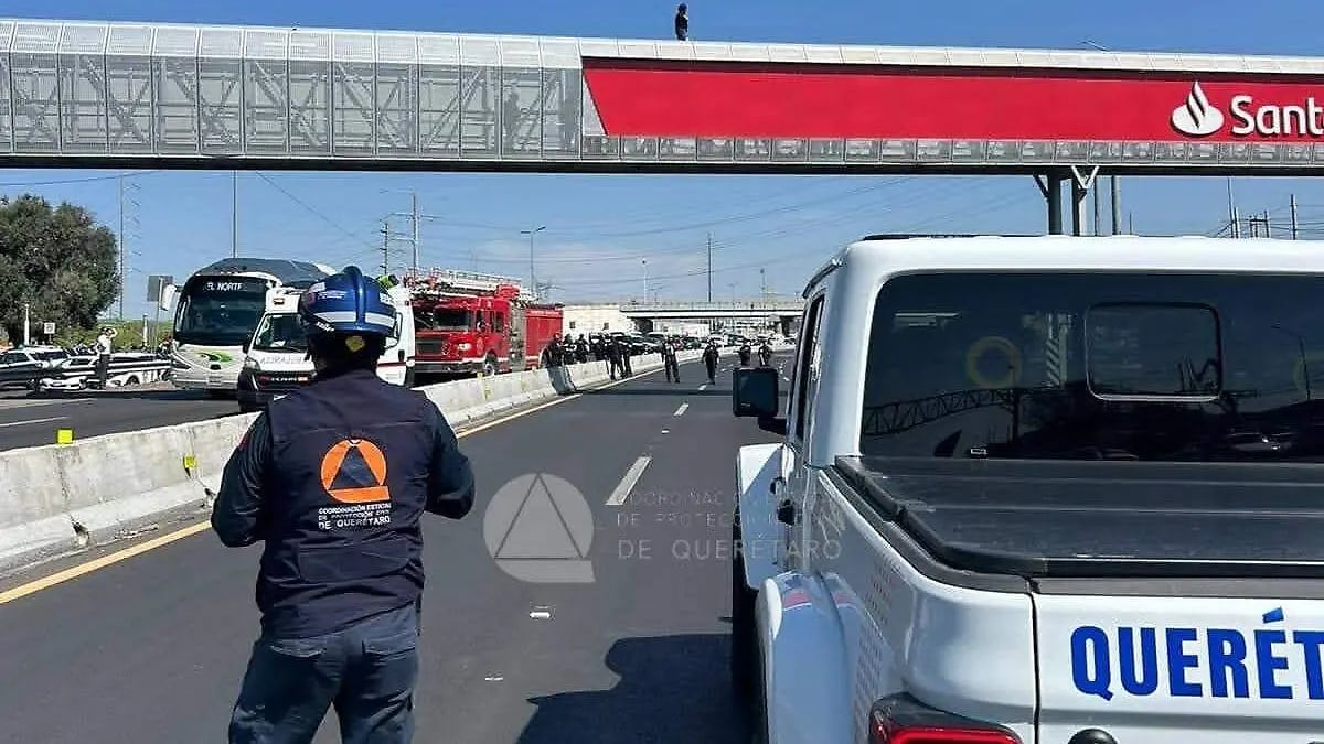 Emergency responder in protective gear directing traffic on highway with police and fire vehicles visible